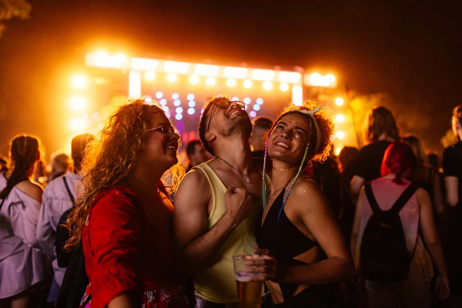 Freunde trinken Bier und haben Spaß beim Musikfestival